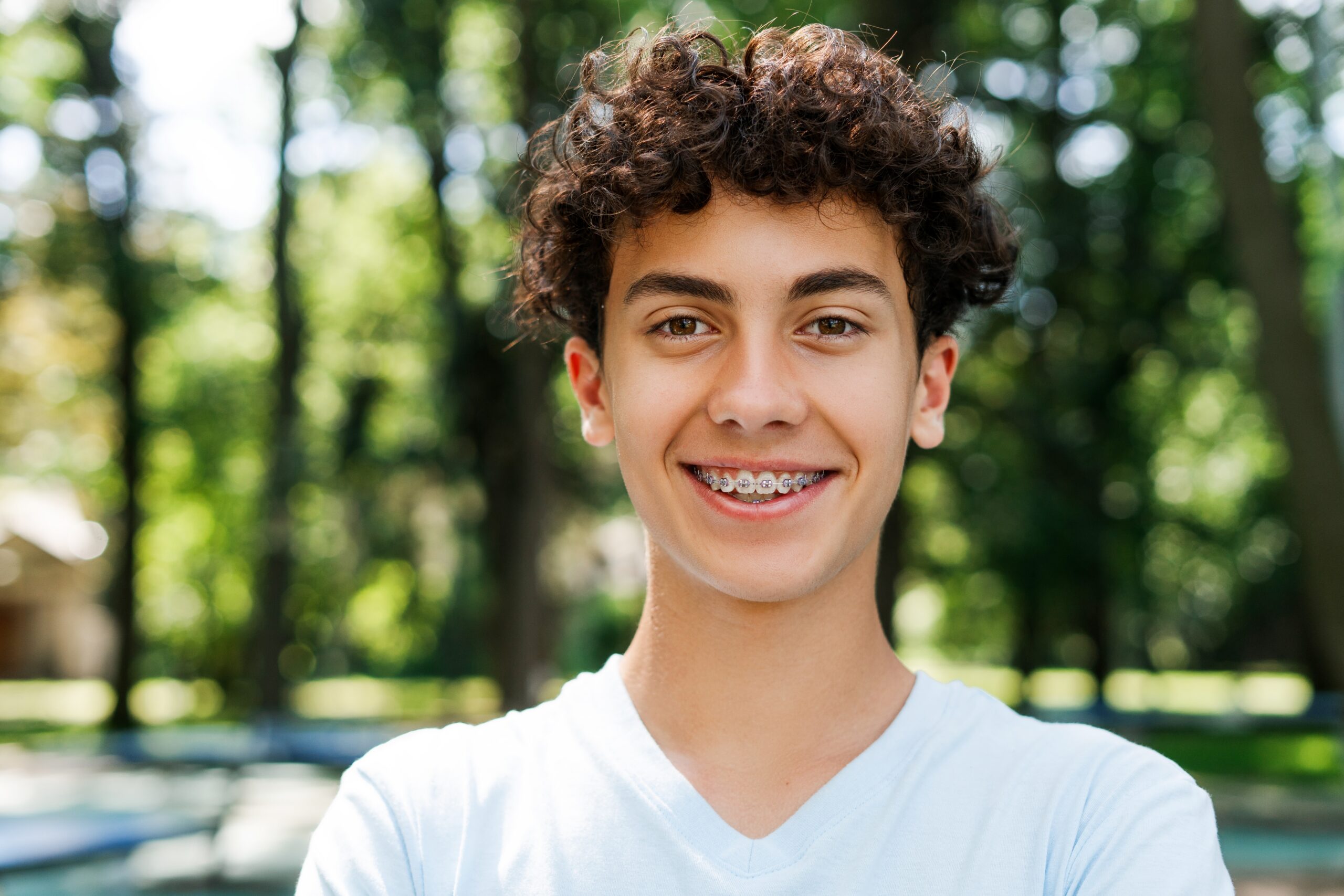 Portrait,Of,Smiling,Teenager,Boy,With,Braces,Looking,At,Camera