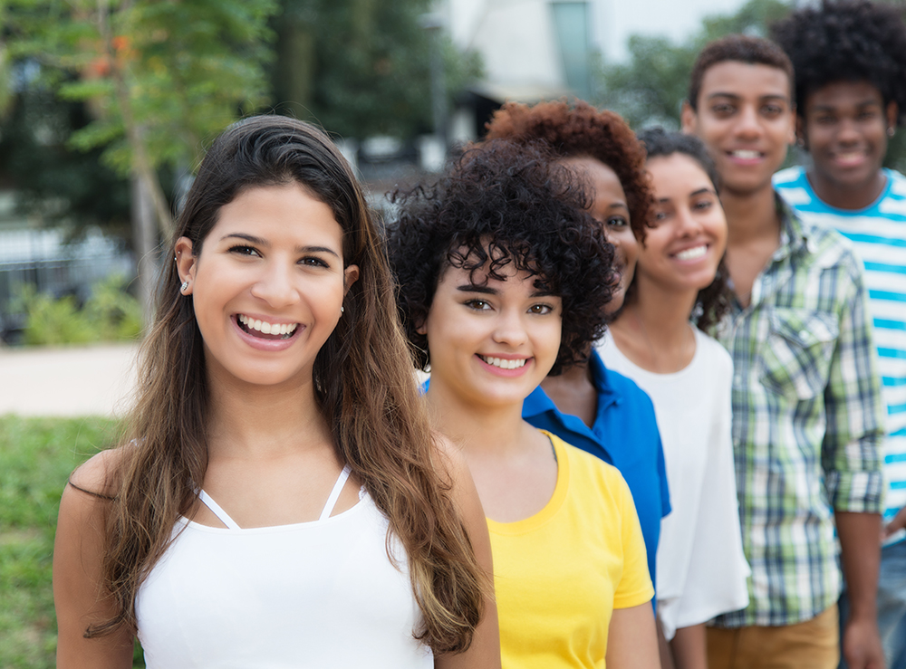 Group of multicultural young adults in a row outdoor in the city in the summer